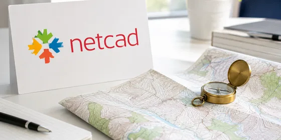 Netcad logosu yanında topoğrafik harita paftası ve pusula sade aydınlık çalışma masasında doğal ışıkla